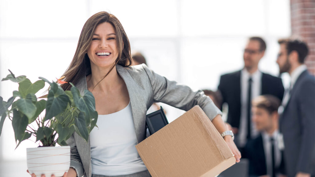 A person smiling while decluttering an organized workspace.