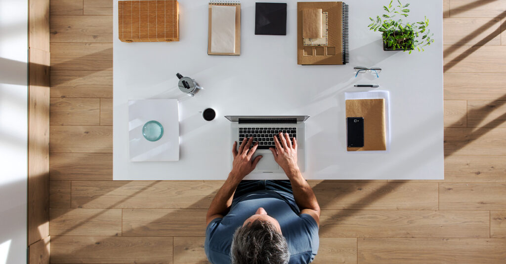 An organized home office with a person focused on their work.