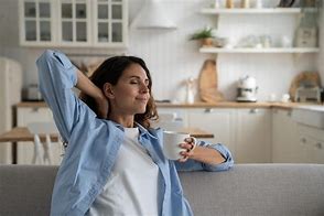 A person enjoying tea in a clean, serene living room.