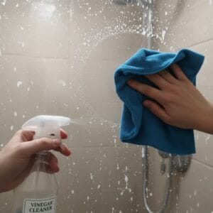 cleaning shower glass with vinegar and microfiber cloth