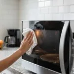Wiping microwave door with vinegar solution and microfiber cloth